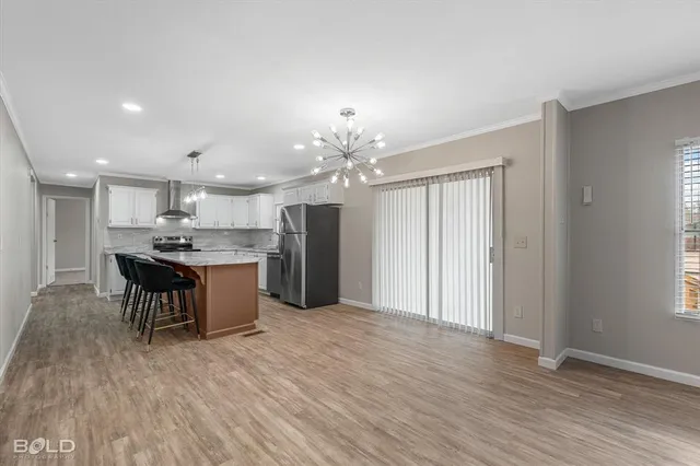 a view of a livingroom with a fireplace a ceiling fan and wooden floor