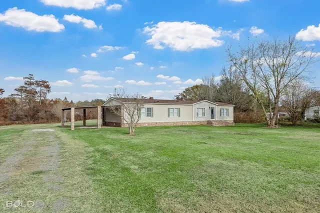 a view of a big yard with a house in the background