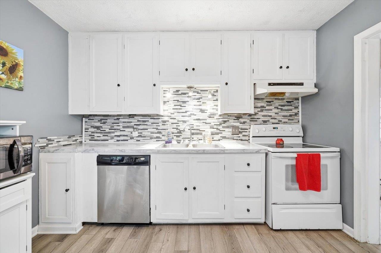 1296 New Hope Road Staunton, VA 24401 - Photo 8 of 37 a kitchen with stainless steel appliances granite countertop a stove and white cabinets