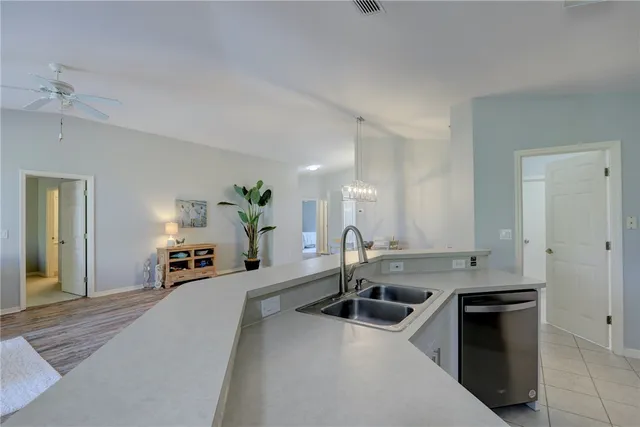 a kitchen with stainless steel appliances granite countertop a sink a stove and a white cabinets