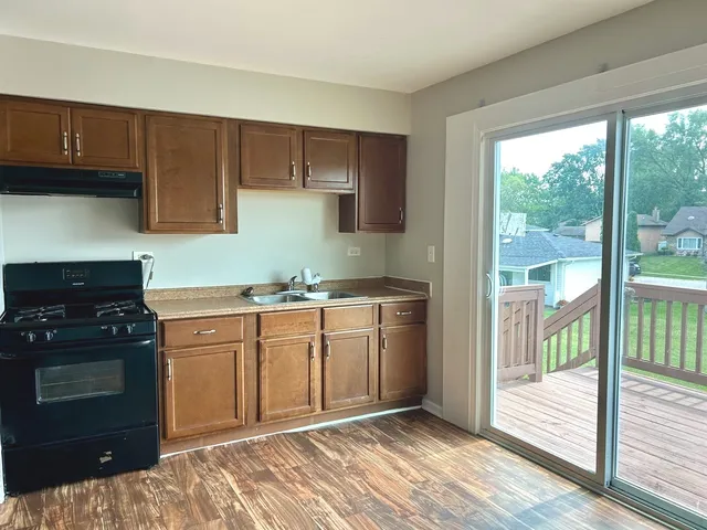a kitchen with granite countertop a stove a sink and a cabinets