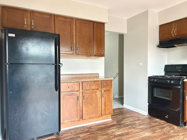 a kitchen with stainless steel appliances granite countertop a refrigerator and a stove top oven