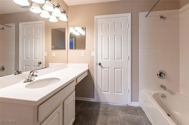 a bathroom with a tub a sink and a mirror