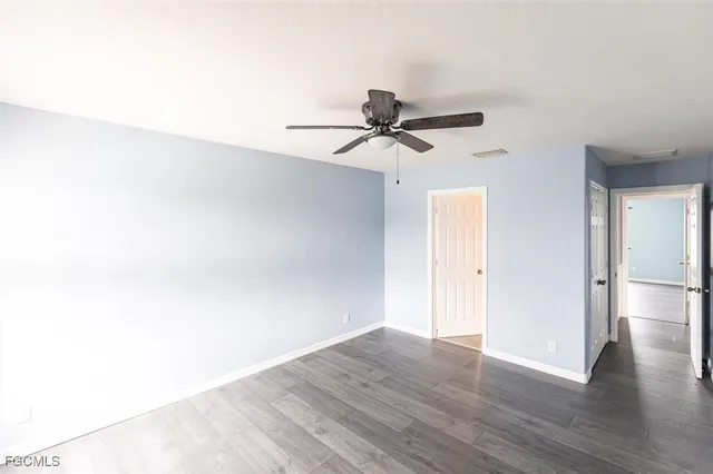 a view of a room with wooden floor and a ceiling fan