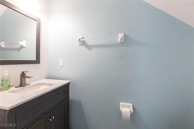 a bathroom with a sink vanity and mirror