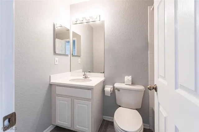 a bathroom with a toilet a sink and mirror