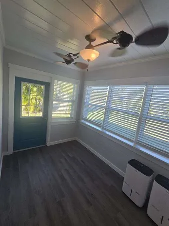 a view of an empty room with a window and a ceiling fan