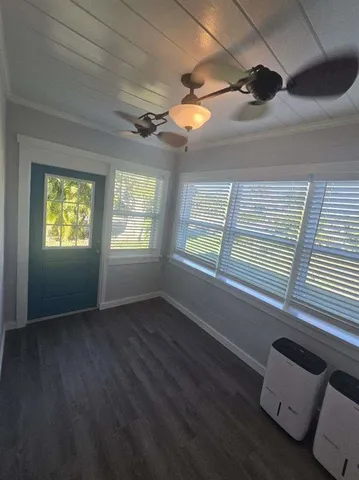 a view of an empty room with a window and a ceiling fan