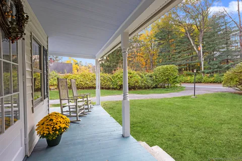 a view of house with a big yard and large trees
