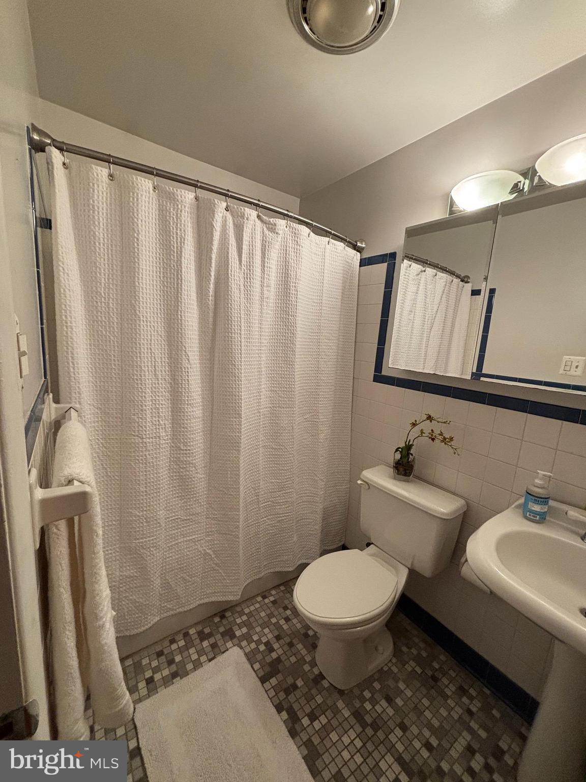 9221 Spring Valley Road Ellicott City, MD 21043 - Photo 27 of 47 a bathroom with a toilet a sink and a shower