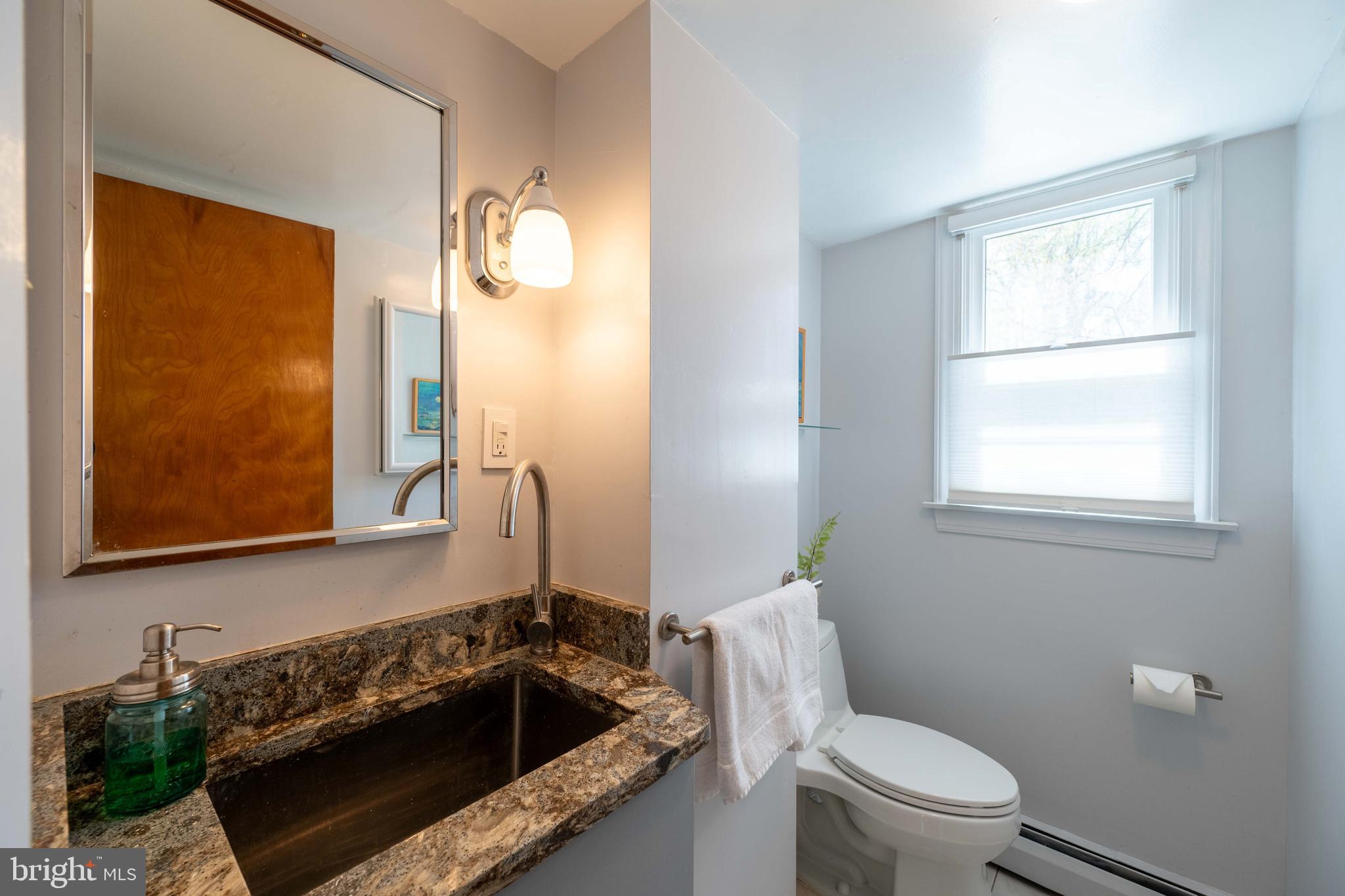 9221 Spring Valley Road Ellicott City, MD 21043 - Photo 33 of 47 a bathroom with a granite countertop sink a toilet and mirror