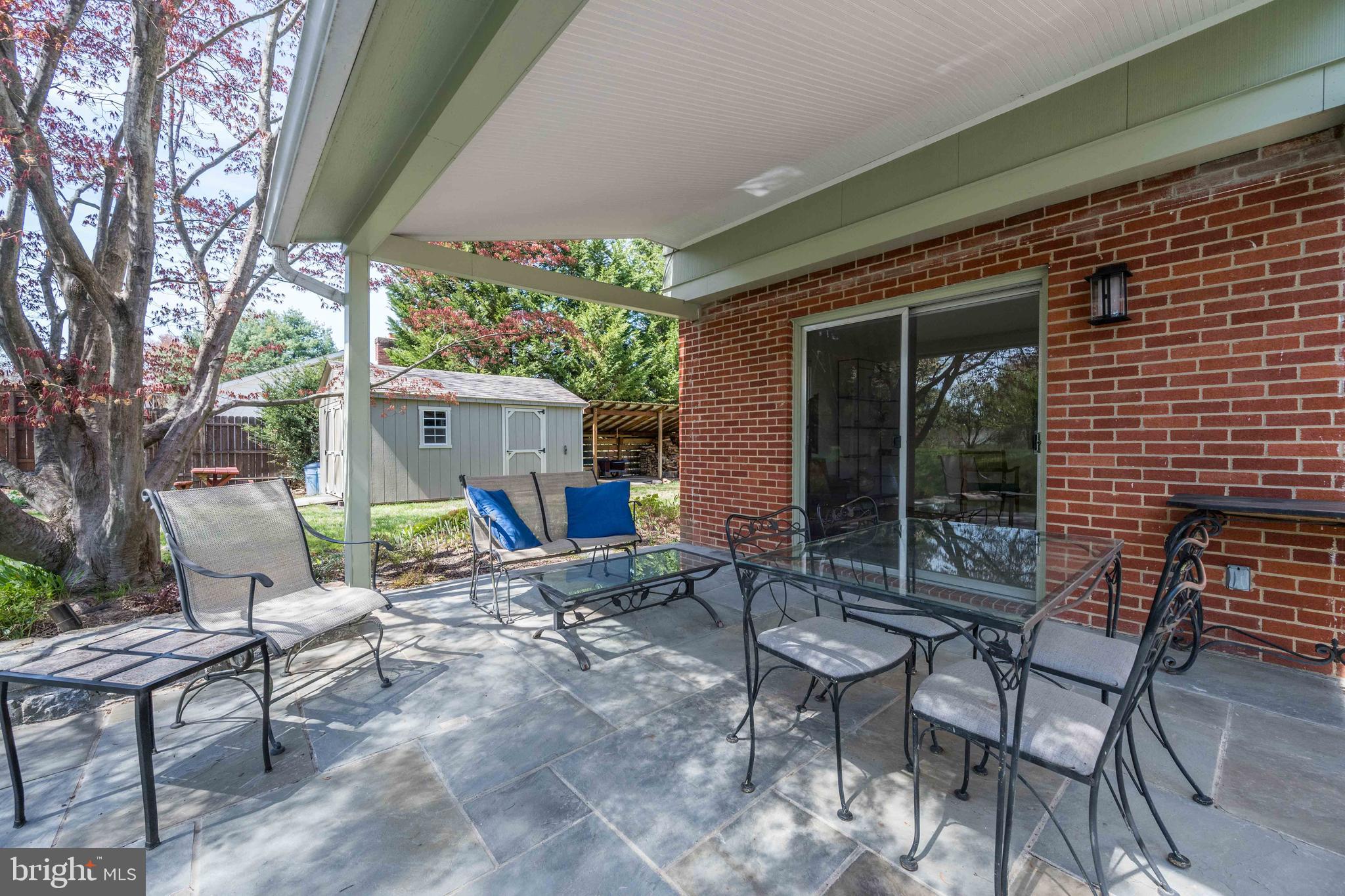 9221 Spring Valley Road Ellicott City, MD 21043 - Photo 38 of 47 a view of a backyard with table and chairs and a large tree