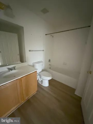 a bathroom with a granite countertop toilet and a sink