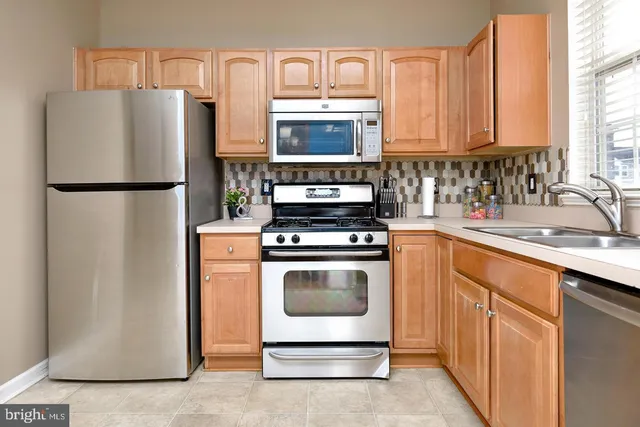 a kitchen with stainless steel appliances a refrigerator stove and sink