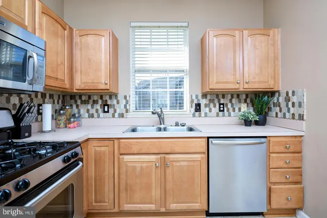 a kitchen with granite countertop a sink stainless steel appliances and cabinets