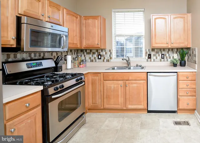 a kitchen with granite countertop a stove top oven microwave and cabinets