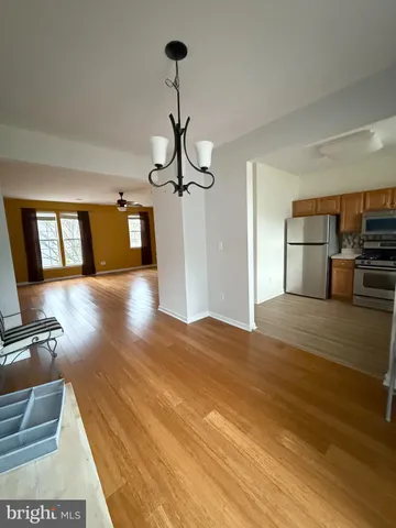 a view of a room with wooden floor staircase and a living room