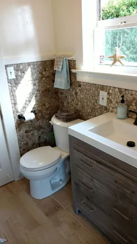 a bathroom with a sink a toilet and a window