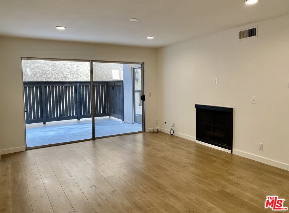 1101 Raintree Circle, Unit 101 Culver City, CA 90230 - Photo 4 of 12 an empty room with wooden floor and windows