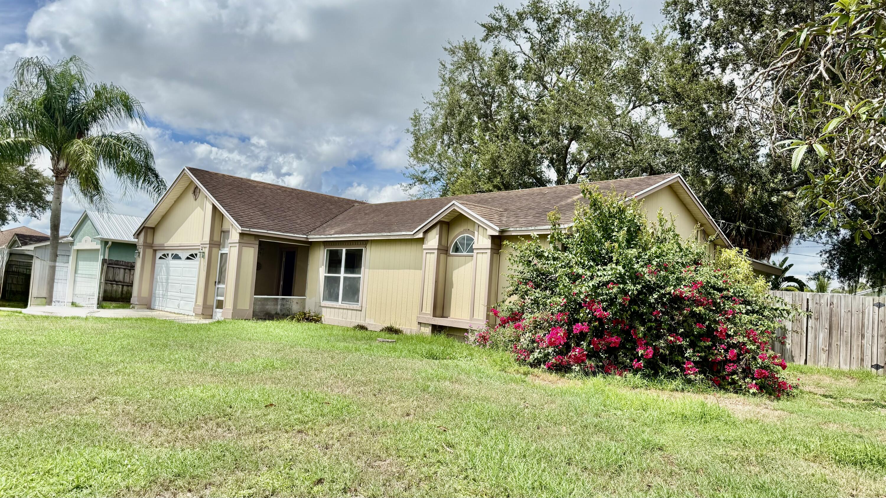 901 Southwest Gaitor Avenue Port St. Lucie, FL 34953 - Photo 1 of 11 a front view of a house with a big yard and large trees