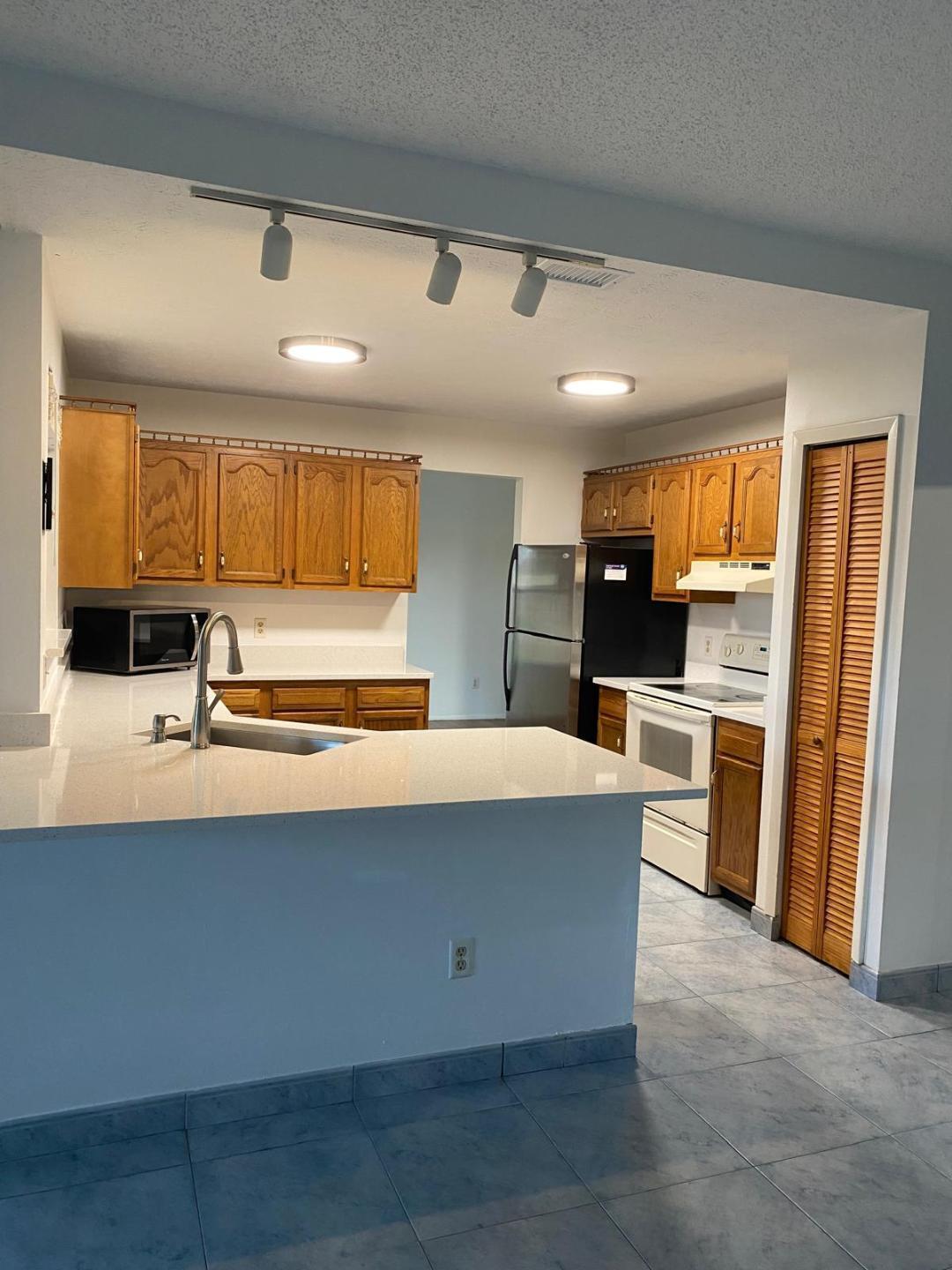 901 Southwest Gaitor Avenue Port St. Lucie, FL 34953 - Photo 2 of 11 a kitchen with stainless steel appliances a stove refrigerator sink and cabinets