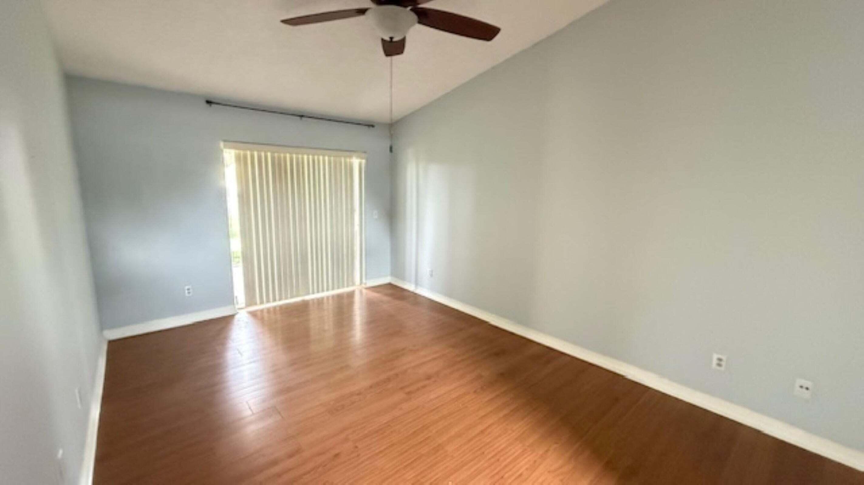 901 Southwest Gaitor Avenue Port St. Lucie, FL 34953 - Photo 9 of 11 an empty room with wooden floor and windows