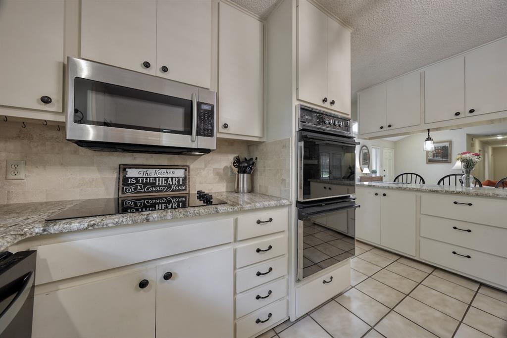 1649 Morningside Trail Hideaway, TX 75771 - Photo 13 of 40 a kitchen with stainless steel appliances a stove microwave and sink