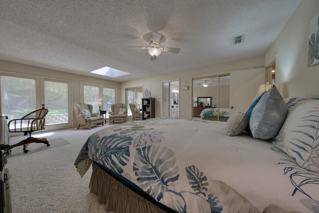 1649 Morningside Trail Hideaway, TX 75771 - Photo 21 of 40 a spacious bedroom with a large bed and a chandelier