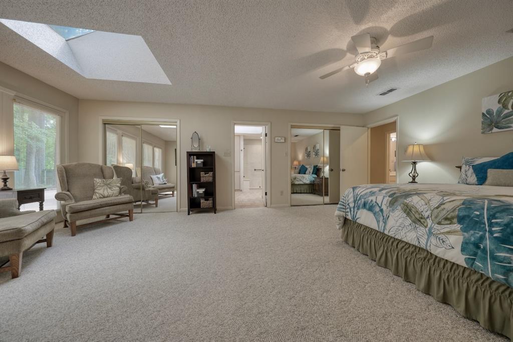 1649 Morningside Trail Hideaway, TX 75771 - Photo 24 of 40 a spacious bedroom with a bed a couch and a chandelier