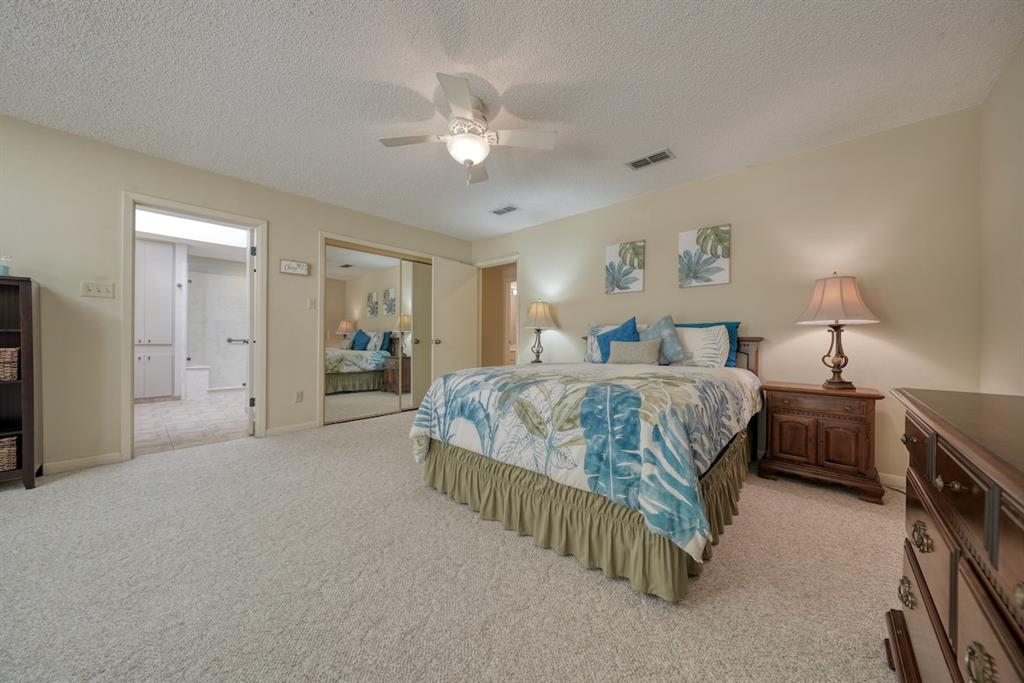 1649 Morningside Trail Hideaway, TX 75771 - Photo 25 of 40 a spacious bedroom with a bed and a chandelier