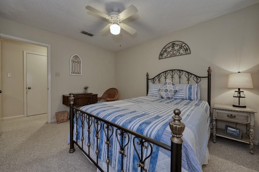 1649 Morningside Trail Hideaway, TX 75771 - Photo 29 of 40 a bedroom with a bed a chandelier and a dresser