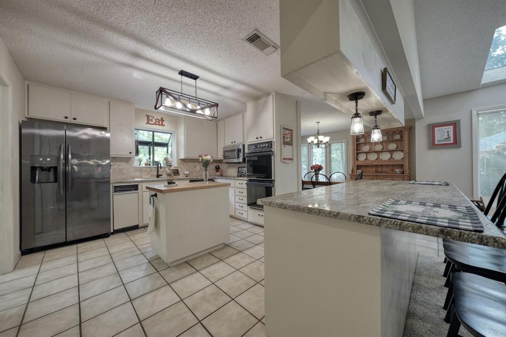 1649 Morningside Trail Hideaway, TX 75771 - Photo 7 of 40 a kitchen with stainless steel appliances granite countertop a sink refrigerator and cabinets