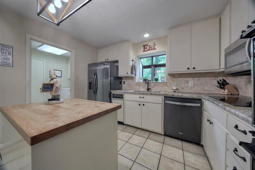 1649 Morningside Trail Hideaway, TX 75771 - Photo 9 of 40 a kitchen with stainless steel appliances granite countertop a sink stove and refrigerator