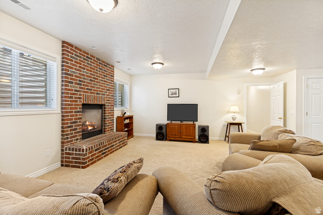 298 North Canyon Road Bountiful, UT 84010 - Photo 45 of 57 Spacious room featuring a brick fireplace with hearth, recessed windows, wall-to-wall carpeting, and overhead lighting