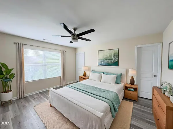 a spacious bedroom with a large bed and a chandelier