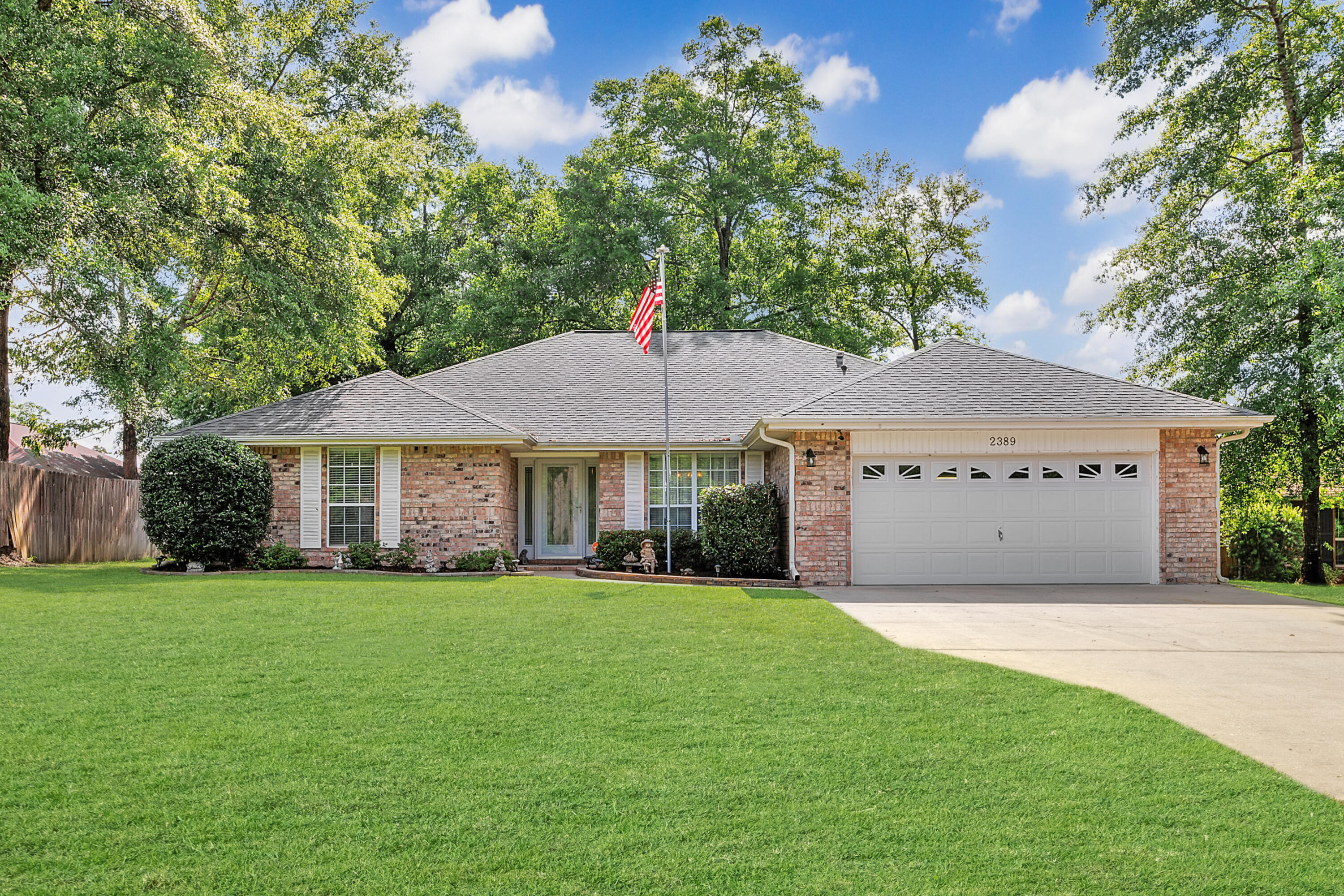 2389 Genevieve Way Crestview, FL 32536 - Photo 1 of 44 a front view of a house with a garden