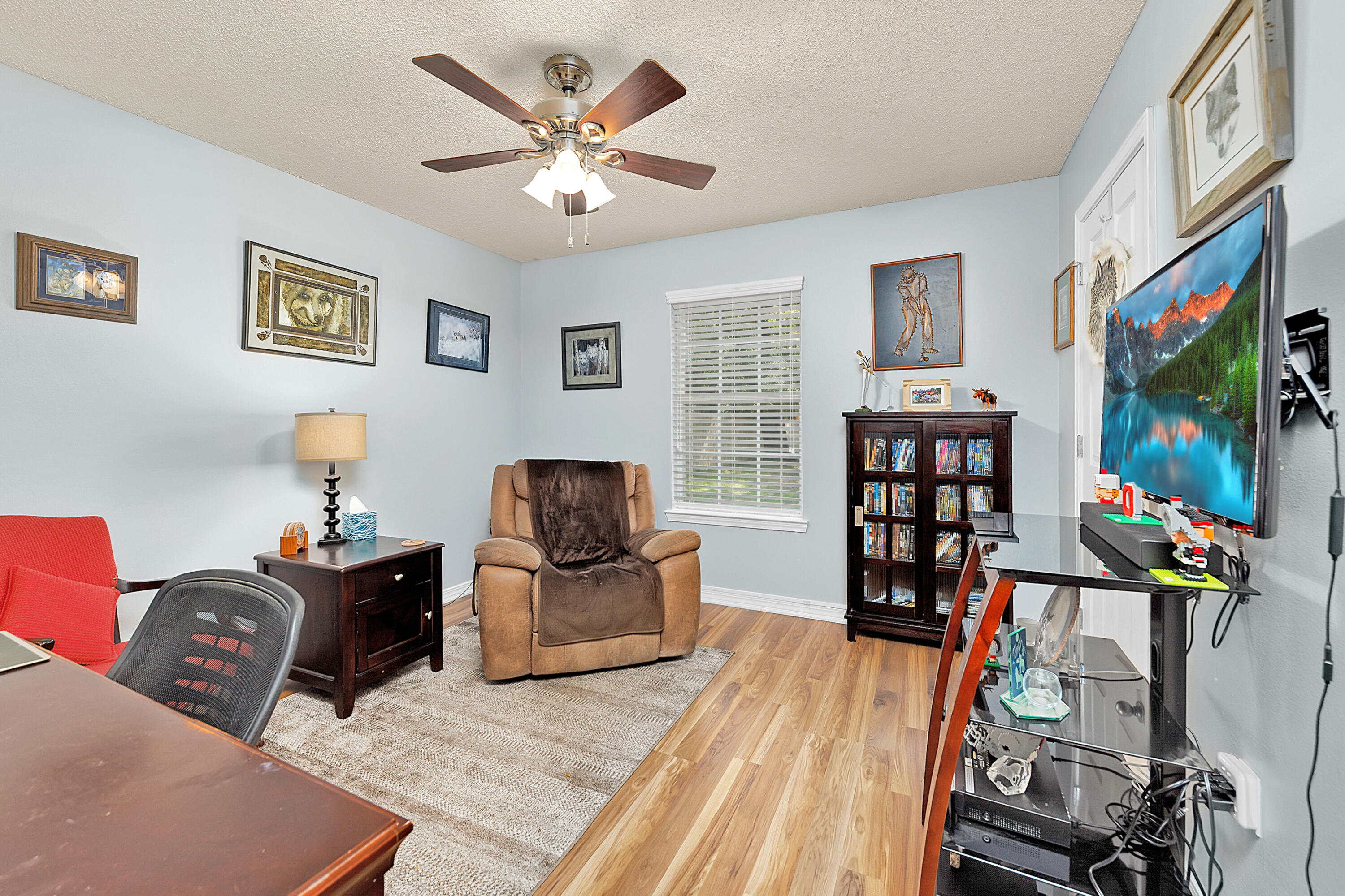 2389 Genevieve Way Crestview, FL 32536 - Photo 18 of 44 a living room with furniture a flat screen tv and gym equipment