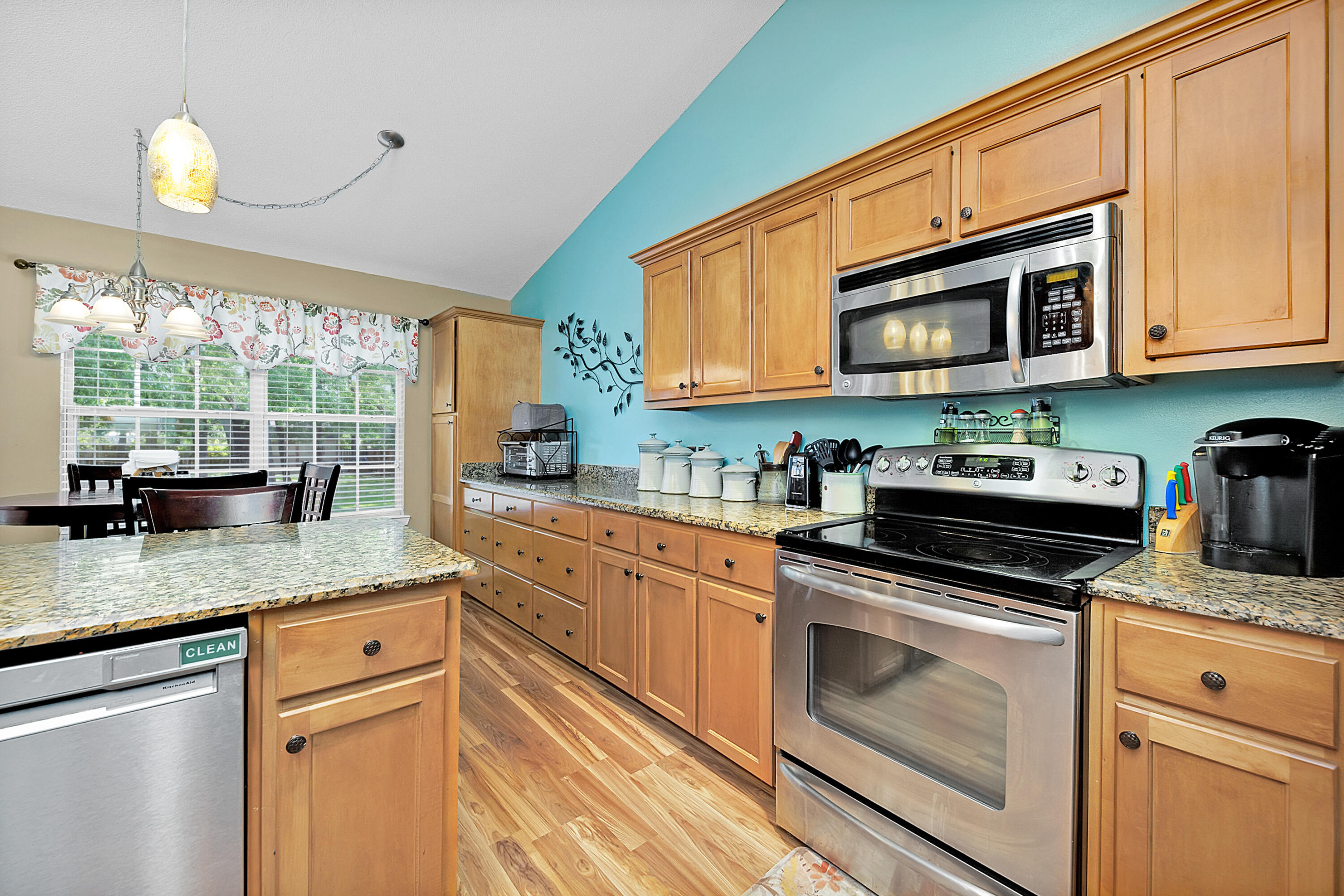 2389 Genevieve Way Crestview, FL 32536 - Photo 21 of 44 a kitchen with stainless steel appliances granite countertop a sink a stove and cabinets with wooden floor
