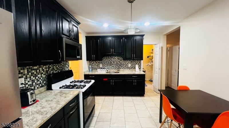 26 Harding Terrace, Unit 1 Newark, NJ 07112 - Photo 11 of 12 a kitchen with a stove and a refrigerator