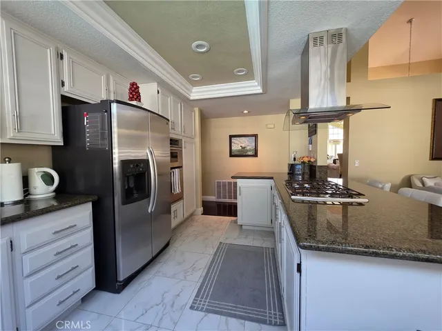 a kitchen with stainless steel appliances granite countertop a sink a stove and refrigerator