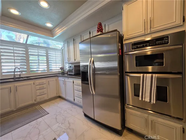 a kitchen with granite countertop a refrigerator and cabinets