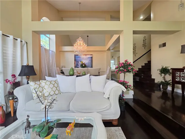 a living room with furniture chandelier and a table