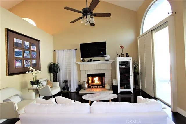 a living room with furniture a fireplace and a flat screen tv