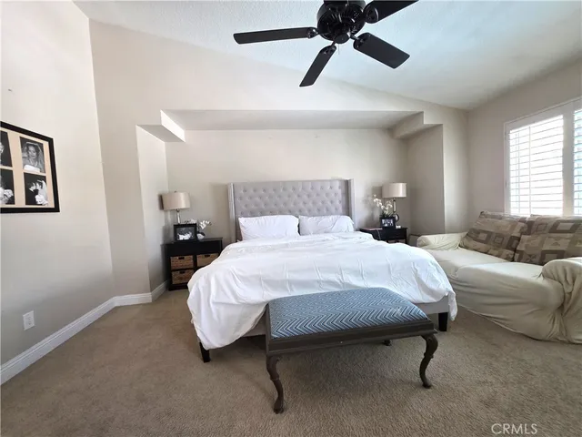 a bedroom with a bed and painting on the wall