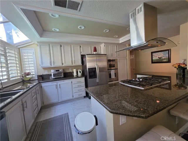 a kitchen with kitchen island granite countertop a sink stove and cabinets