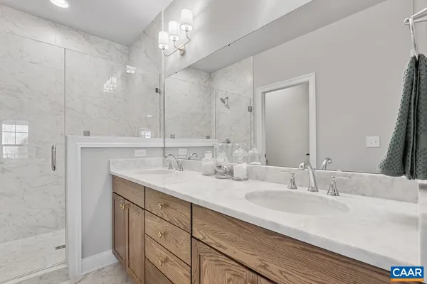 a bathroom with double vanity sinks and a mirror
