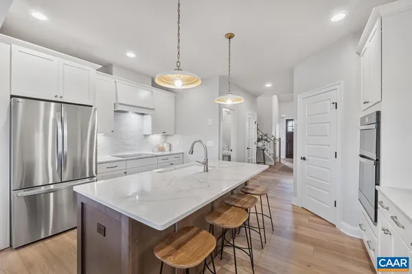 a kitchen with refrigerator and wooden floor
