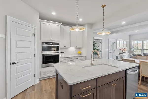 a kitchen with kitchen island a counter space a sink stainless steel appliances and cabinets