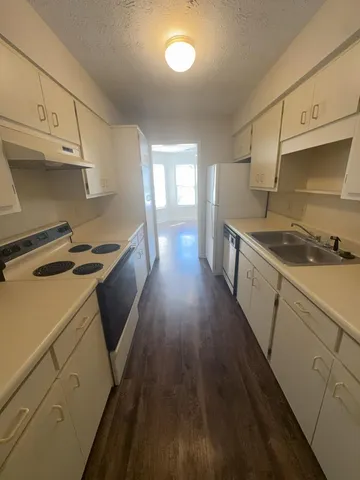 a kitchen with sink a stove and cabinets