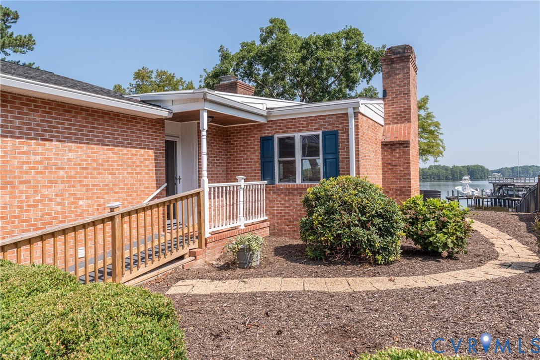 Brick exterior featuring a covered entry, wood ram